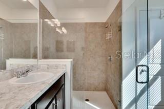 bathroom with vanity and a shower with shower door