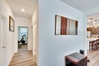 corridor with light hardwood / wood-style flooring