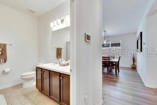 bathroom featuring an inviting chandelier, vanity, toilet, and hardwood / wood-style floors