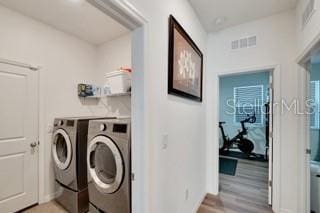 laundry area featuring washer and dryer and light wood-type flooring