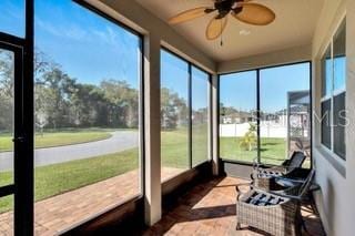 sunroom / solarium featuring ceiling fan