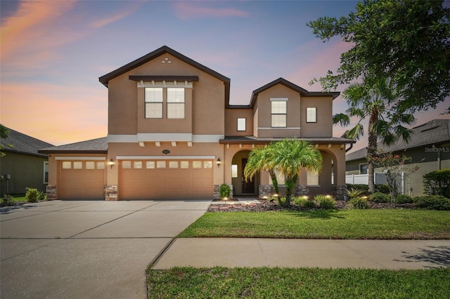 view of front of property with a garage and a lawn