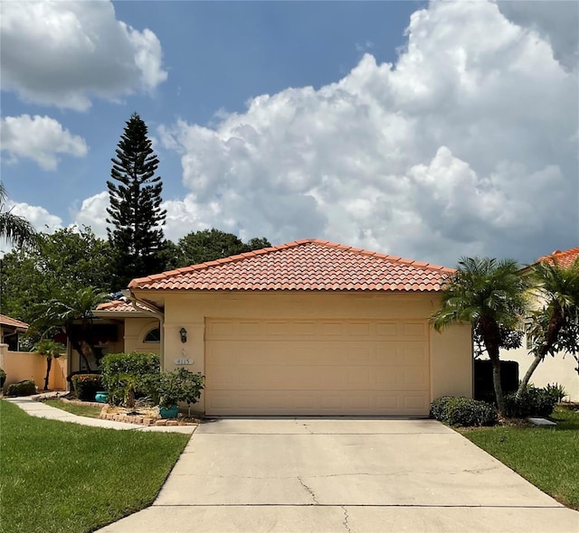 mediterranean / spanish house with a garage and a front yard