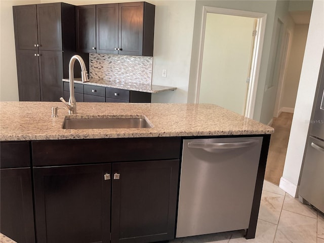 kitchen featuring light stone countertops, tasteful backsplash, dishwasher, sink, and dark brown cabinets