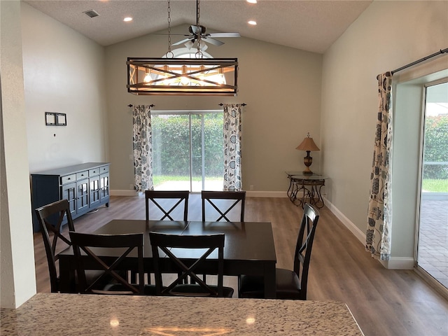 dining room featuring wood-type flooring, a textured ceiling, lofted ceiling, and ceiling fan