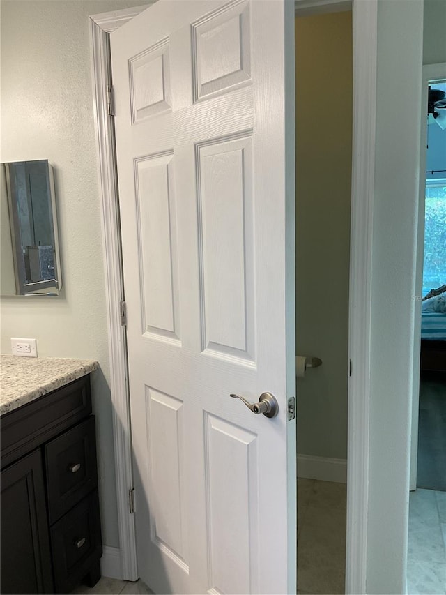 bathroom with electric panel, tile patterned flooring, and vanity