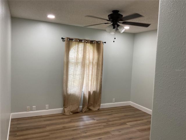 unfurnished room with ceiling fan, a textured ceiling, and wood-type flooring