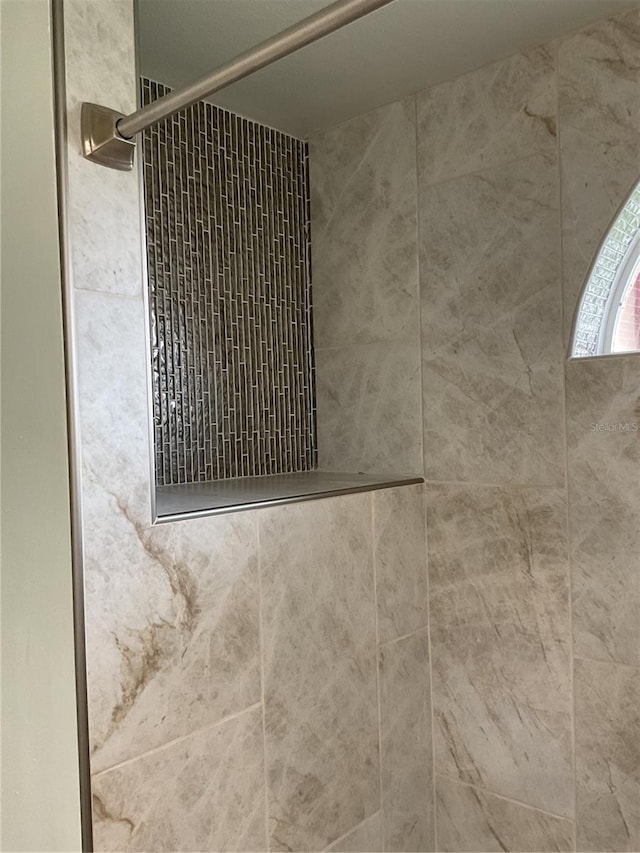 interior details featuring tiled shower