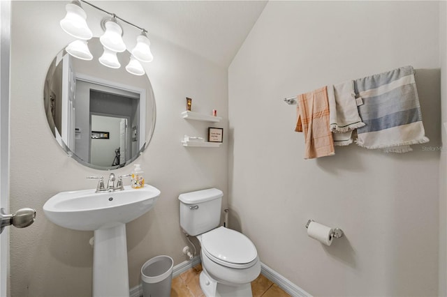 bathroom with tile patterned flooring, vaulted ceiling, and toilet