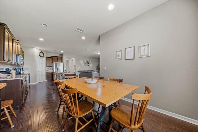 dining space featuring sink and dark wood-type flooring