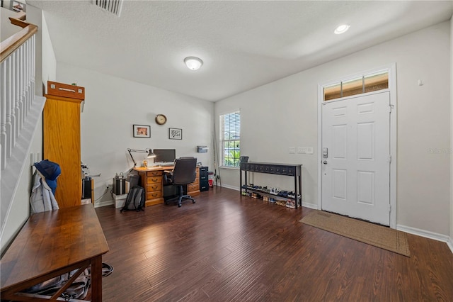 home office with dark hardwood / wood-style flooring and a textured ceiling