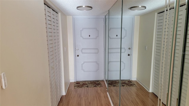 doorway featuring a textured ceiling and hardwood / wood-style flooring