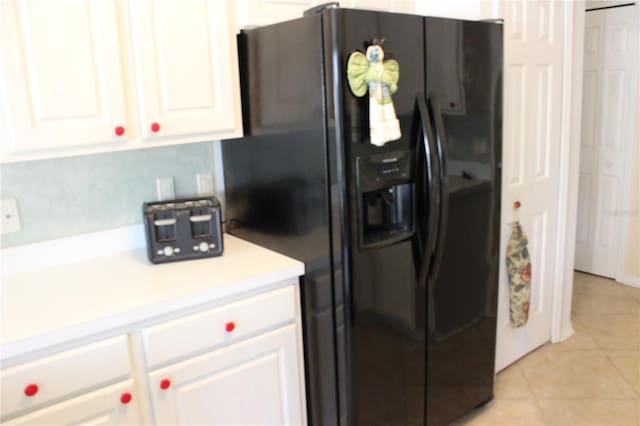 kitchen featuring white cabinetry, black refrigerator with ice dispenser, and light tile patterned floors