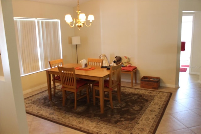 tiled dining room featuring a chandelier