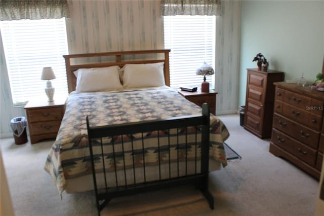 carpeted bedroom featuring multiple windows