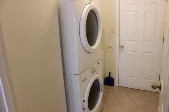 laundry room featuring stacked washer / dryer and light tile patterned floors