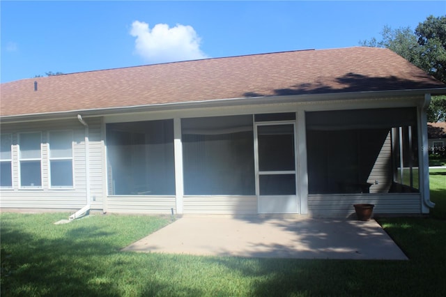 rear view of house featuring a sunroom and a lawn