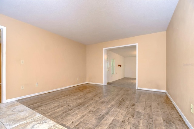 spare room featuring hardwood / wood-style floors and a textured ceiling