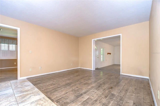 empty room featuring a textured ceiling and wood-type flooring