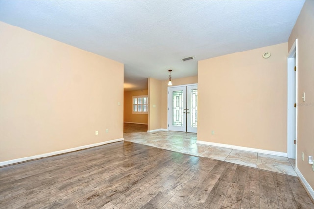 empty room featuring light wood-type flooring and a textured ceiling