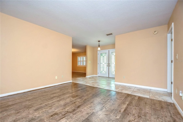 unfurnished room featuring light wood-type flooring and a textured ceiling