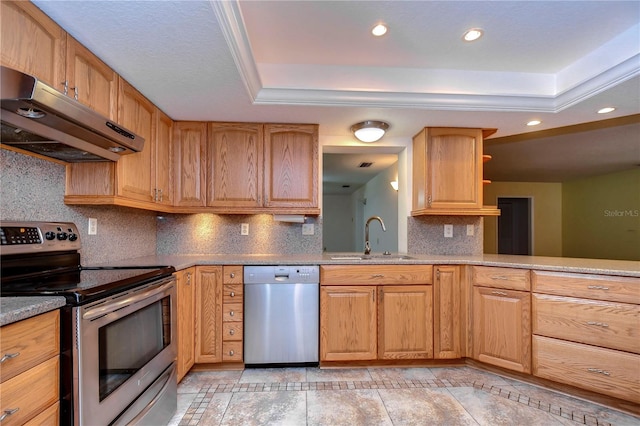 kitchen featuring tasteful backsplash, a tray ceiling, sink, appliances with stainless steel finishes, and light tile patterned floors