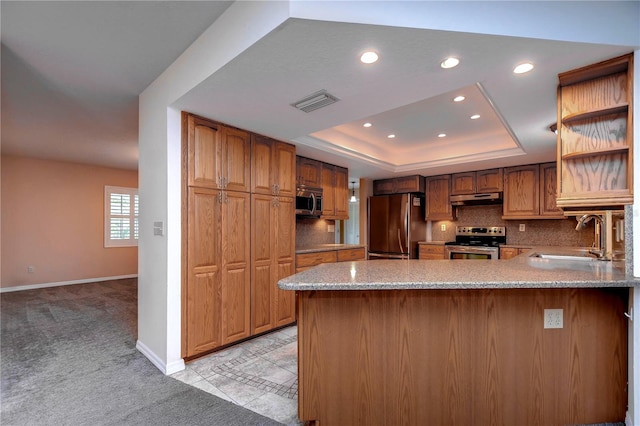 kitchen with tasteful backsplash, light colored carpet, appliances with stainless steel finishes, a raised ceiling, and sink