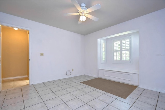 tiled empty room featuring ceiling fan