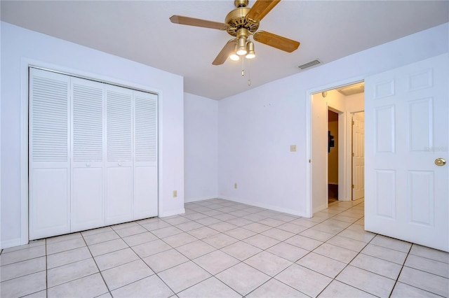 unfurnished bedroom featuring light tile patterned flooring, ceiling fan, and a closet