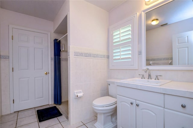 bathroom featuring vanity, tile walls, toilet, and tile patterned floors