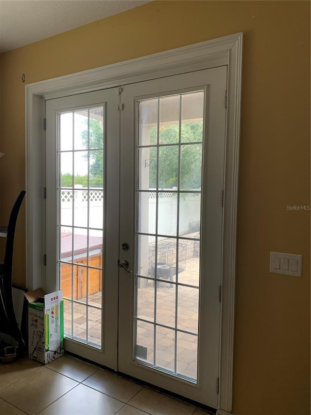 doorway to outside with light tile patterned flooring, plenty of natural light, and french doors