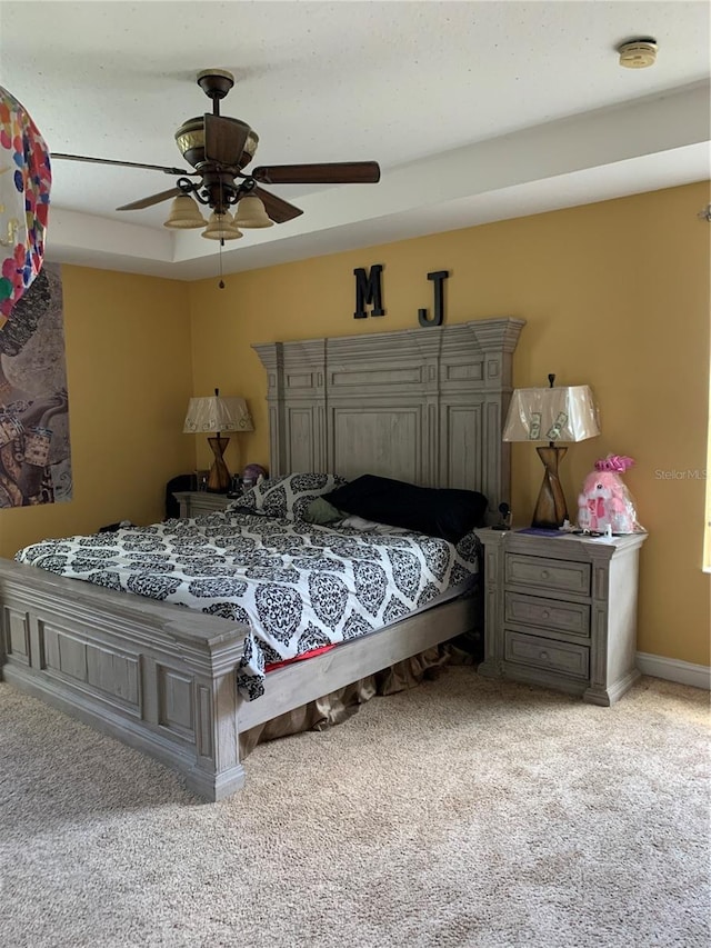 carpeted bedroom with ceiling fan and baseboards