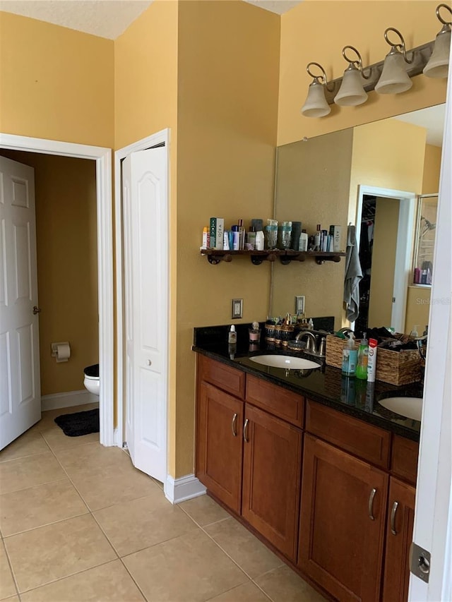 bathroom with tile patterned floors, a closet, toilet, and a sink