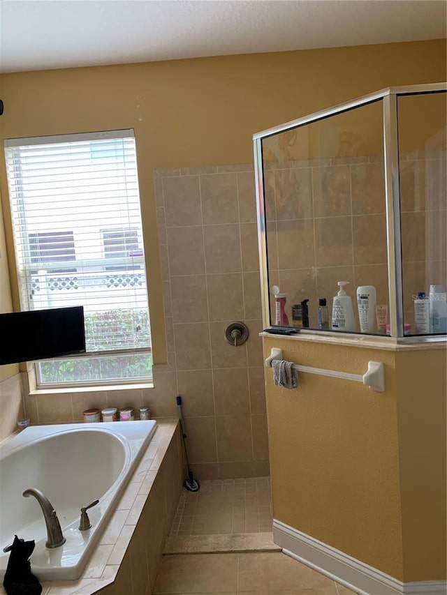 full bathroom with tile patterned flooring, a garden tub, and walk in shower