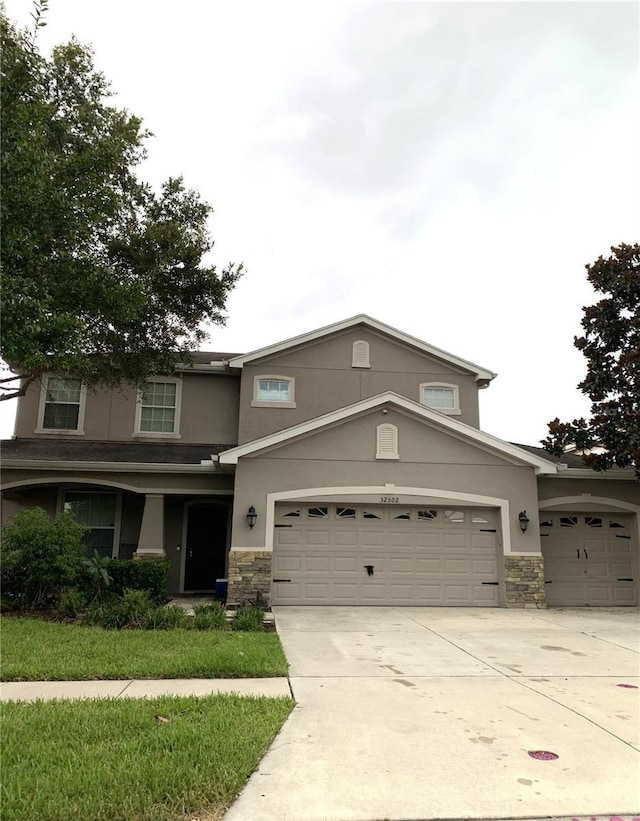 32502 Summerglade Dr, Wesley Chapel, FL 33545 - traditional-style house with stone siding, stucco siding, concrete driveway, and an attached garage