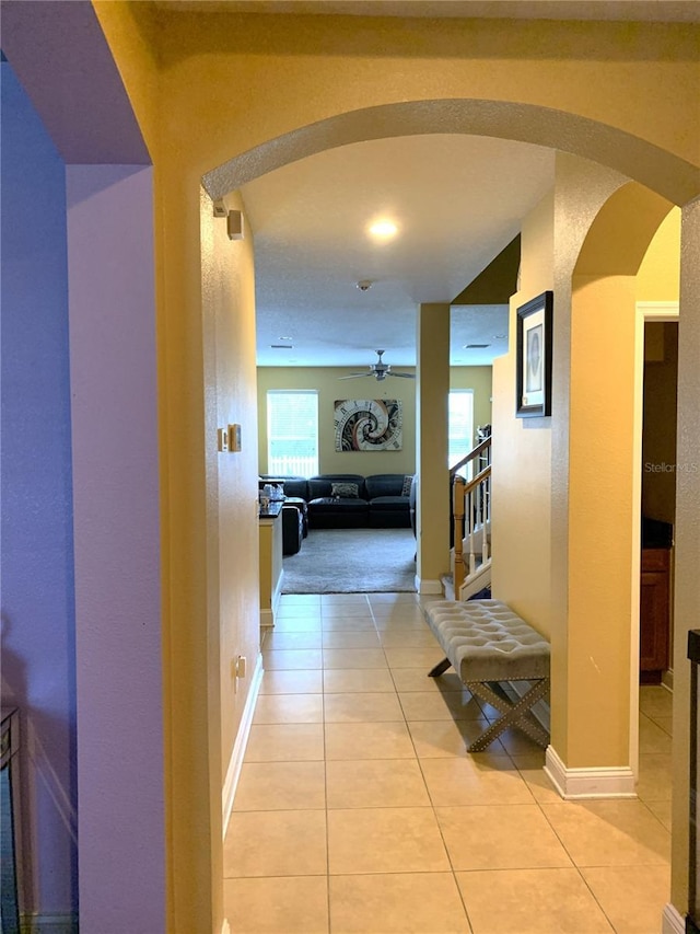 32502 Summerglade Dr, Wesley Chapel, FL 33545 - hallway featuring arched walkways, light tile patterned floors, and baseboards