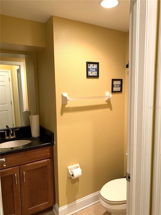 bathroom featuring tile patterned flooring, vanity, and toilet