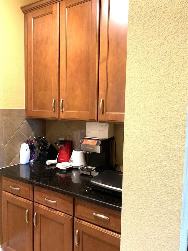 kitchen featuring dark stone counters and tasteful backsplash