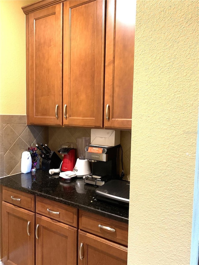 32502 Summerglade Dr, Wesley Chapel, FL 33545 - kitchen with a textured wall, tasteful backsplash, dark stone countertops, and brown cabinets