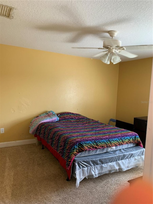 bedroom featuring ceiling fan, a textured ceiling, and carpet floors