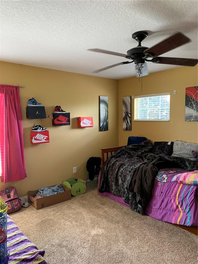 bedroom with carpet flooring, a textured ceiling, and ceiling fan