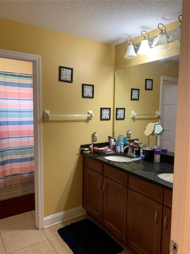 32502 Summerglade Dr, Wesley Chapel, FL 33545 - full bathroom featuring a textured ceiling, tile patterned floors, double vanity, a shower with curtain, and baseboards