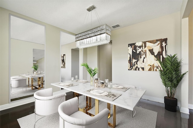 dining space featuring dark hardwood / wood-style flooring and a textured ceiling