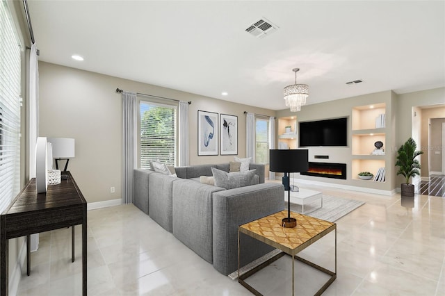 living room with a notable chandelier and built in features