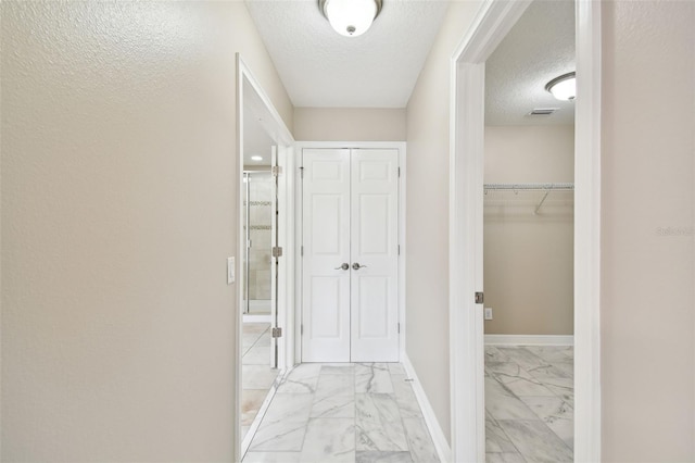 hall with a textured ceiling