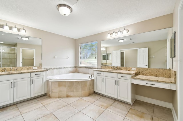 bathroom featuring tile patterned floors, vanity, separate shower and tub, and a textured ceiling