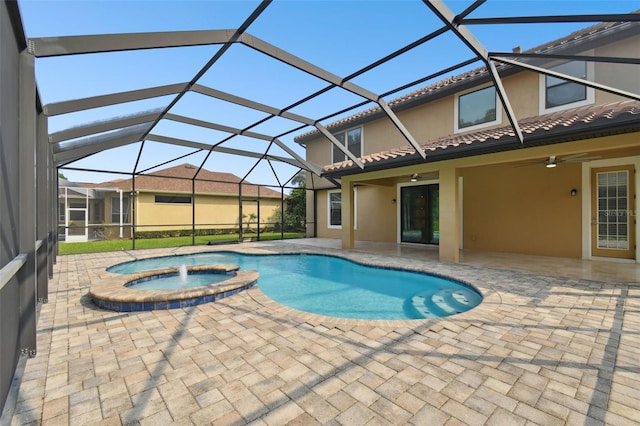 view of swimming pool featuring glass enclosure, ceiling fan, a patio area, and an in ground hot tub