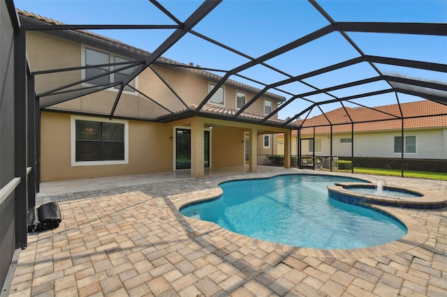 view of pool featuring an in ground hot tub, a patio, glass enclosure, and ceiling fan