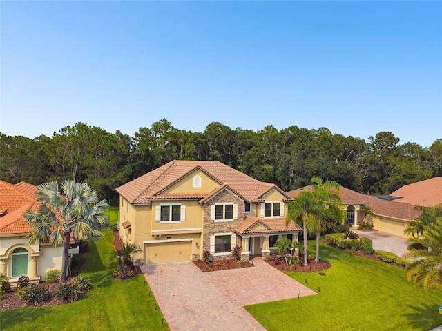 mediterranean / spanish-style home featuring a front lawn and a garage