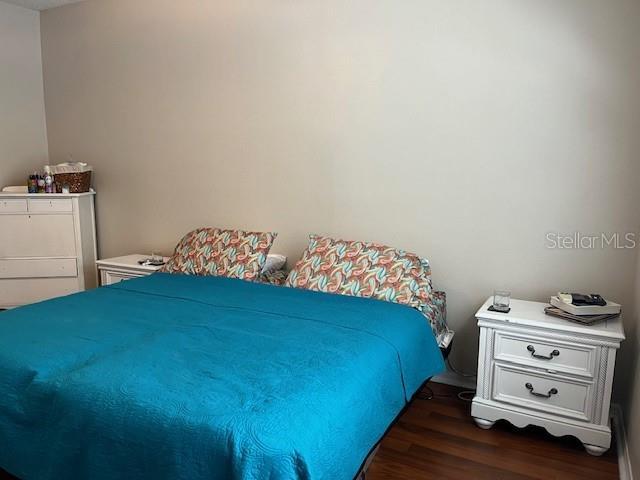 bedroom with dark wood-type flooring